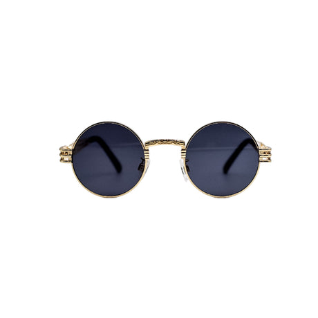 Round sunglasses with gold frame and dark lenses on a light gray background